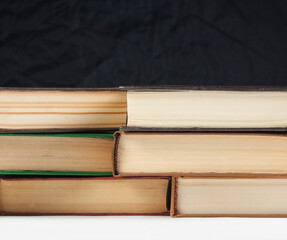 Old books on the table, on a black background, white table