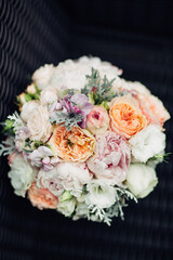 Wedding bouquet made of white and pink peonies stands on brown chair
