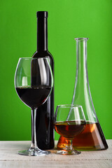 Bottles and glasses with wine and whiskey on wooden surface