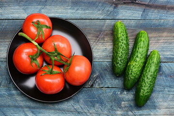 diet concept, cucumbers with tomato on plate on blue vintage