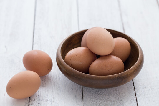 eggs in a wooden bowl on old wooden table top view