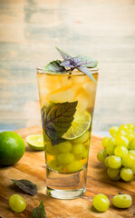 Fresh cocktail with grape, lime and basil leaves. Shallow depth of field.