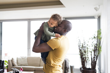Fototapeta premium Young afro-american father with his little daughter at home.