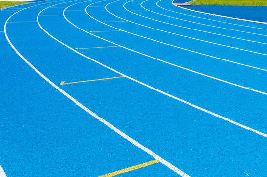 Blue Running track .Lanes of blue running track.Running track with blue asphalt and white markings in outdoor stadium.selective focus.