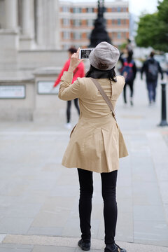 A woman takes pictures of the sights of the city. London, Great Britain.