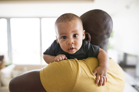 Young afro-american father holding his baby son in the arms