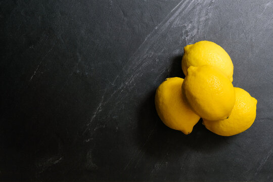 Lemons are on top of stone table. Top view with copy space, flat lay. Low key image.