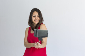 Naklejka premium Happy beautiful woman taking a selfie with smart phone over white background. Lifestyle. Wearing casual clothing.