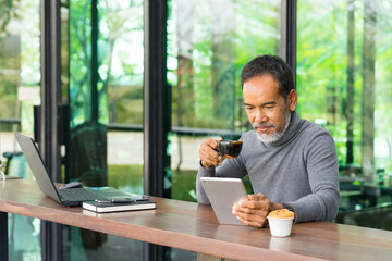 Portrait Smiling Attractive mature man with white stylish short beard using smartphone. Serving...