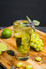 Fresh cocktail with grape, lime and basil leaves. Shallow depth of field.