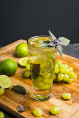 Fresh cocktail with grape, lime and basil leaves. Shallow depth of field.