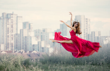 The ballerina doingis so de sha (split) In a Red Dress int he City