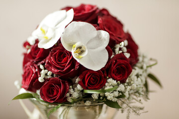 composizione floreale composto da rose rosse e orchidee bianche dentro vaso di vetro