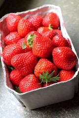 Red ripe  strawberries in cardboard box container. Juicy berries in carton.