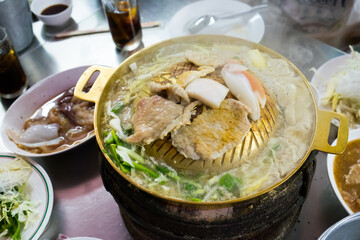 Grilled sliced pork and meat on hot brass pan surrounding with smoke. Asian BBQ-Style.