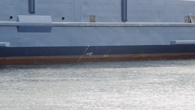 Passenger ferry departure from a harbor at closeup on beautiful calm water with breeze gust