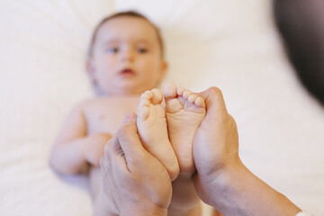 father hands holding his new born baby feet