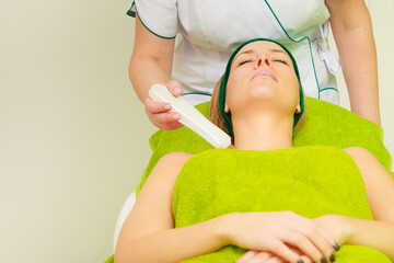 Beautician doing ultrasound cavitation peeling on woman