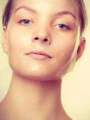 Woman in facial peel off mask.