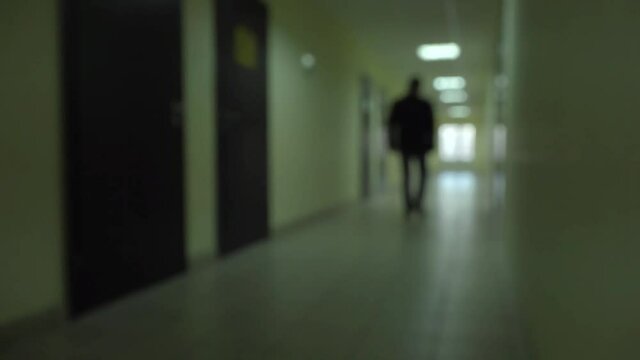 Silhouette of a man runs through the dark corridor. Dismissal.The Ghost of a businessman .The path to success.