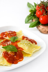 Ravioli with tomato sauce and basil isolated on white background
