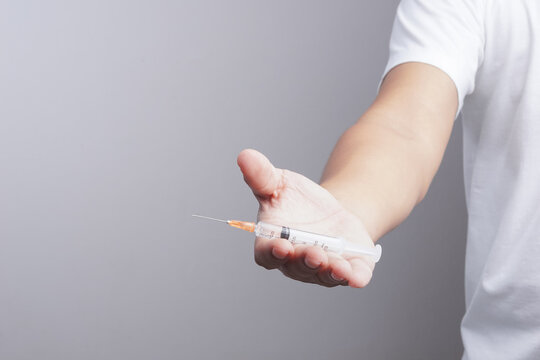 Hand holding syringe as drug patient