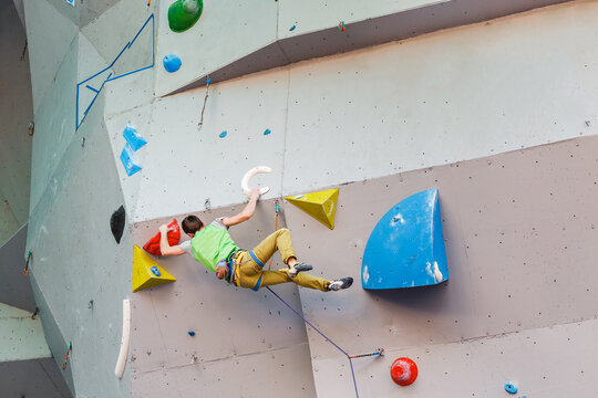 Male Climber sportsman hanging on artificial Climbing Wall, Competition in difficulty contest