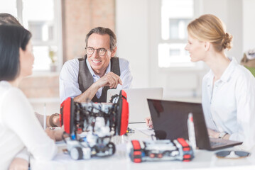 Obraz premium Positive engineers creating robot in office