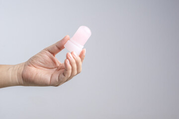 Hand holding natural mineral alum crystal stick use as underarm deodorant