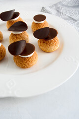 Choux with cream and chocolate. Small cakes with chocolate.