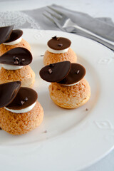 Choux with cream and chocolate. Small cakes with chocolate.