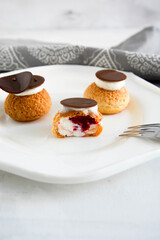 Choux with cream and chocolate. Small cakes with chocolate.