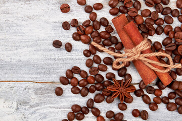 Coffee grain on wooden background. Cinnamon and badian on table. Coffee pleases the eye.