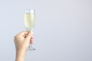 Hand holding glass of champagne for celebration on white backgroun