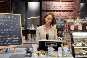 Fototapeta na wymiar happy woman or barmaid with cashbox at cafe