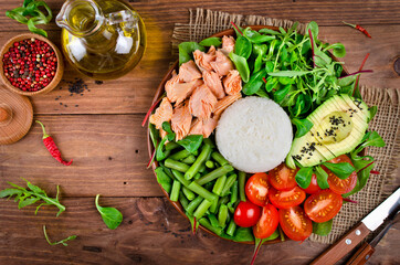 Healthy salad bowl with salmon, rice, tomatoes, avocado, mix salad, green beans