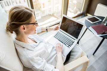 Elegant young lady sitting in chair with notebook