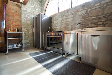 beautiful professional inox kitchen in rustic interior