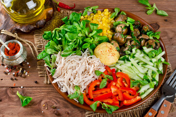 Healthy salad bowl with chicken, mushrooms, corn, cucumbers, sweet pepper and mix salad