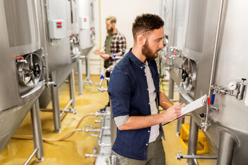Naklejka na ściany i meble men with clipboard at craft brewery or beer plant