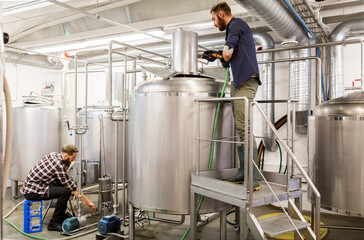 men working at craft beer brewery kettles