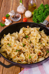 Pasta farfalle with fried meat, mushrooms and vegetables
