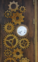 Wooden door in the cafe decorated in the form of clock gears and watches.