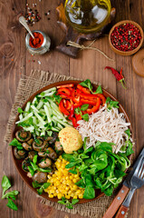 Healthy salad bowl with chicken, mushrooms, corn, cucumbers, sweet pepper and mix salad