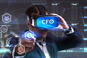 Business, Technology, Internet and network concept. Young businessman working in virtual reality glasses sees the inscription: CFO