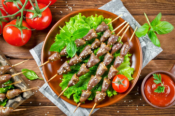 Chicken hearts on a barbecue sticks topped with sesame seeds