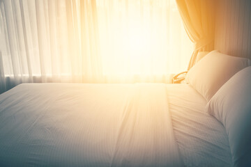 Close up pillows on bed sheet in bedroom with sun lay effect ,vintage process style