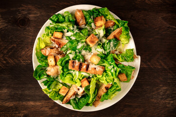 Chicken Caesar salad on rustic background with copyspace - obrazy, fototapety, plakaty