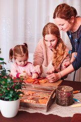 Naklejka premium Family decorating baked Christmas gingerbread
