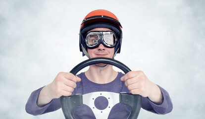 Man in red helmet and goggles with steering wheel. car driver concept